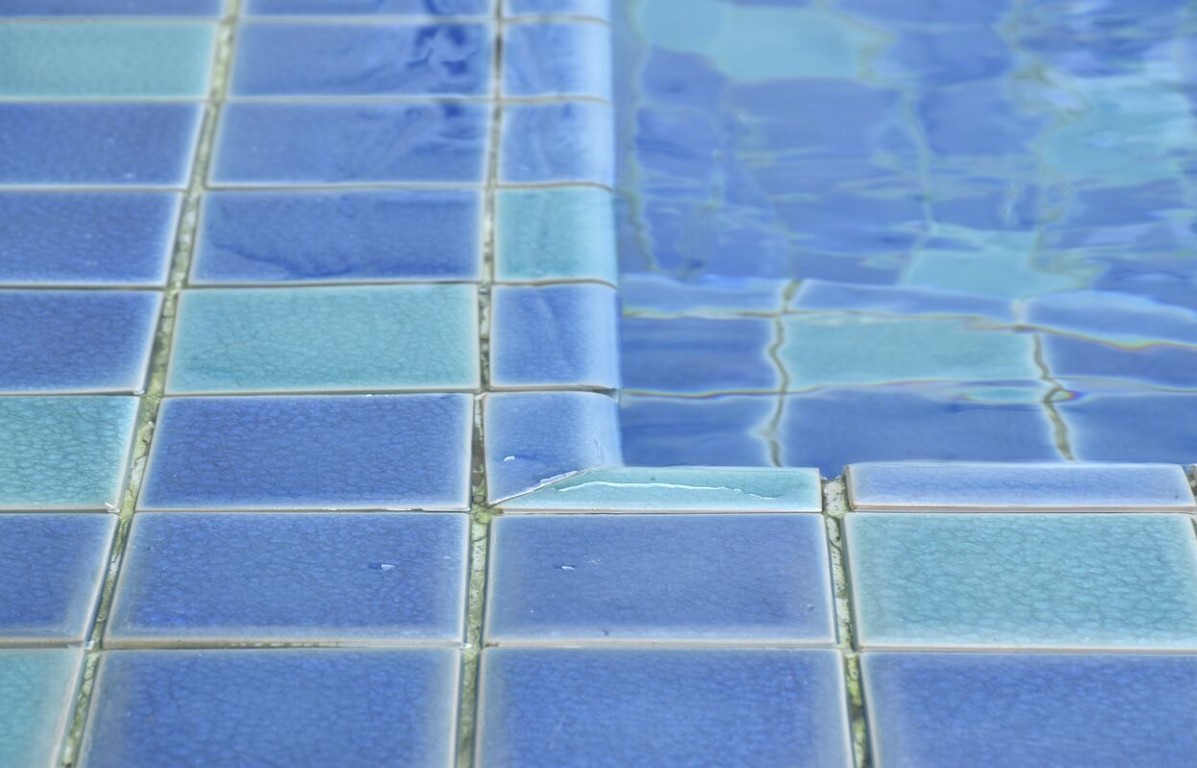 Close-up inspection of pool tiles showing professional attention to detail